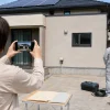 V2H補助金申請のため戸建ての駐車場と設置予定場所を撮影する様子